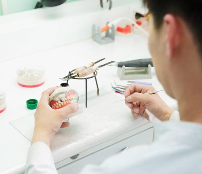 a technician working on creating a set of dentures