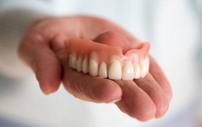 a person holding an upper denture