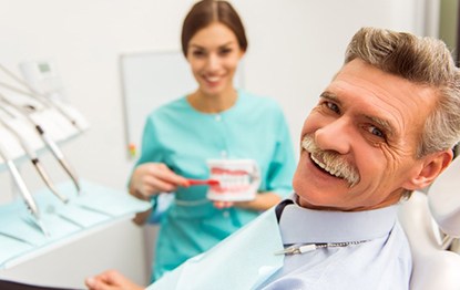 a patient smiling after receiving his new dentures